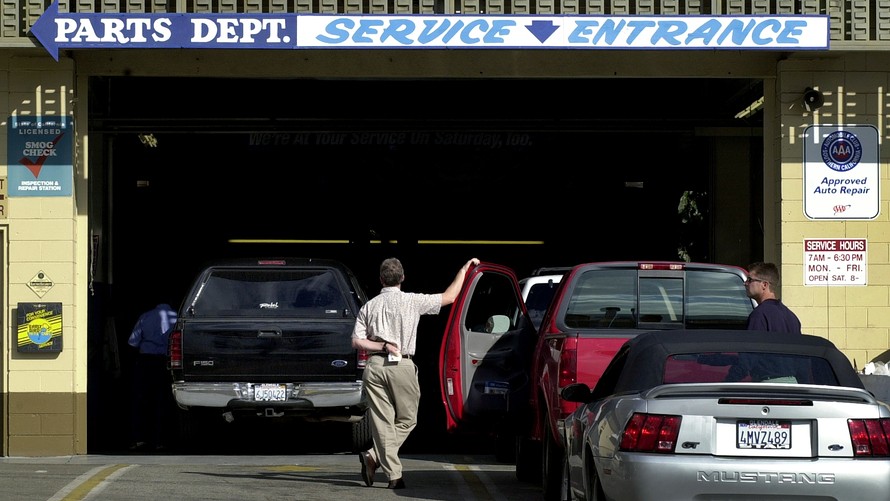 Man standing by car at dealership